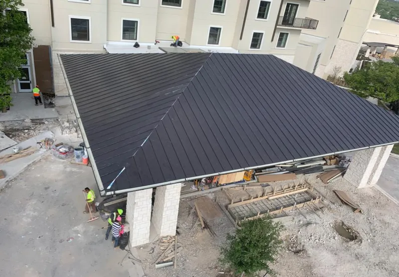 Metal roofing installation team working on a commercial building in Warren